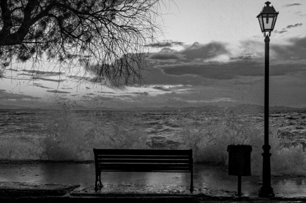Image en noir et blanc d’un banc face à la mer. Il représente le thème de l'article - le suicide d'un athée - de la Revista Espírita de 1861.