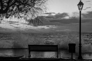 Image en noir et blanc d’un banc face à la mer. Il représente le thème de l'article - le suicide d'un athée - de la Revista Espírita de 1861.